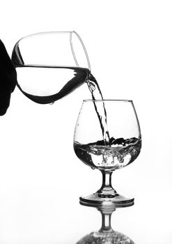 wine glass water pouring to wine glass on glass table (gray scale)