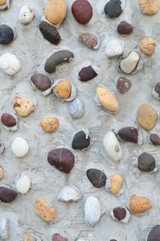 Pebbles in concrete wall texture background