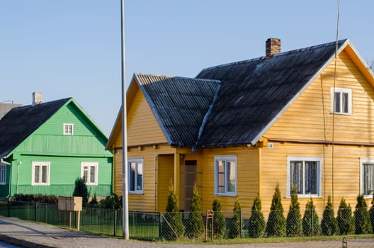 beautiful rural green and yellow painted wooden houses along the street