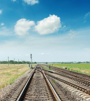 crossing of two railroads and blue sky with clouds