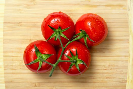 Top view of fresh tomatoes on wooden chopping board 