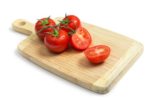 Fresh tomatoes on wooden chopping board, isolated on white background with shadow 