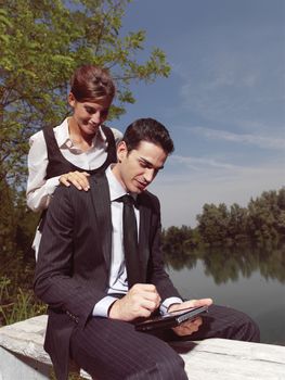 Beautiful young people using PDA outdoors 