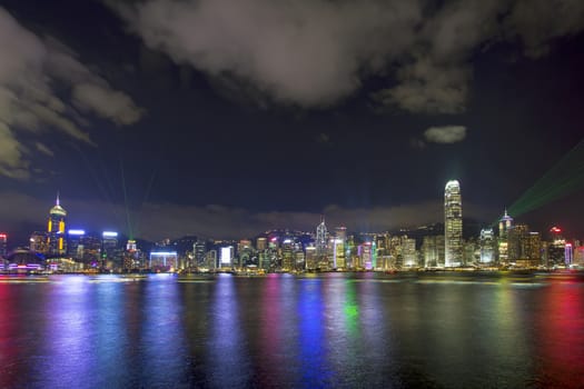 HONG KONG - MAY 28, 2014: Symphony of Lights Show and Hong Kong Island City Skyline Along Victoria Harbour at Night viewed from Tsim Sha Tsui in Kowloon. This is a nightly show and is a major tourist attraction.