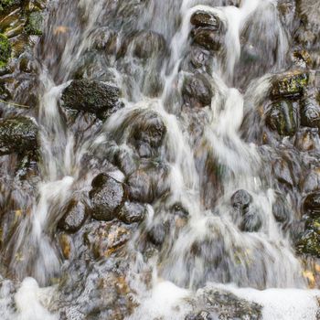 Water flowing over big stones, square crop