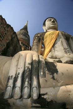 Stone hand of Buddha covered by orange fabric from the temple of Wat Yai Chai Mongkol in Ayutthaya, Thailand.