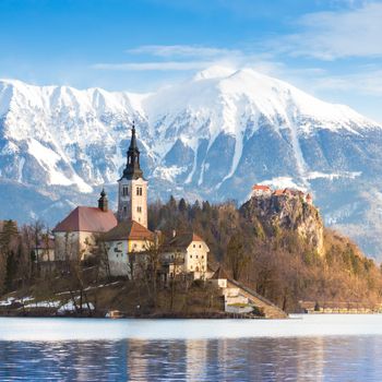 Panoramic view of Julian Alps, Lake Bled with St. Marys Church of the Assumption on the small island; Bled, Slovenia, Europe.