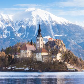 Panoramic view of Julian Alps, Lake Bled with St. Marys Church of the Assumption on the small island; Bled, Slovenia, Europe.