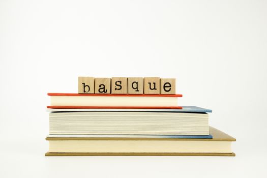 basque word on wood stamps stack on books, conversation and translation concept