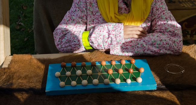 children hands playing retro game with wooden ball figures