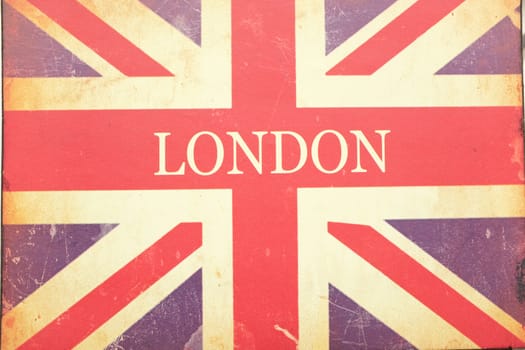 A London and Union Jack sign on old woven fabric with stains and scratches.