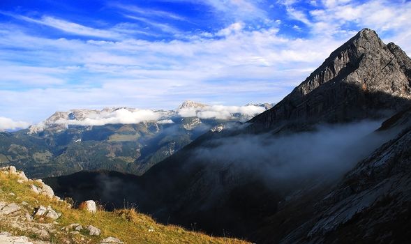 wild mountain valley with slopes of mountains and blue sky