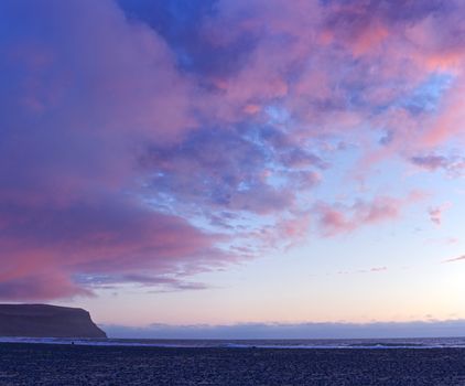 Sunset at the white beach at Iceland ocean coast. Panorama.