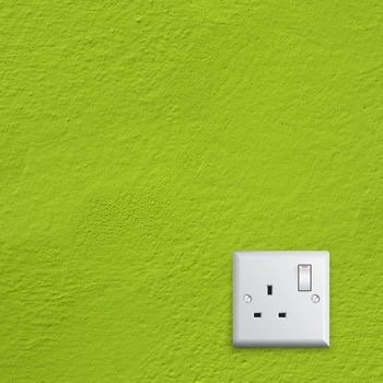 simple white electric great britain socket on green wall
