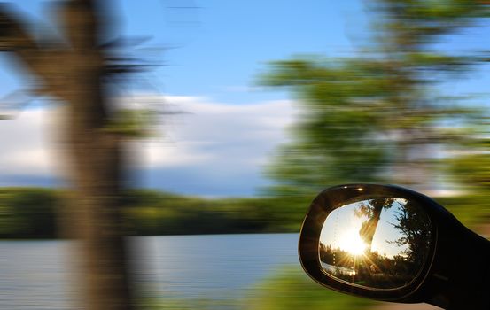 view mirrors in cars at the setting sun, blurred landscape