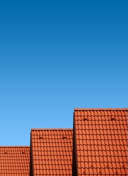 roof with red tiles on a background of blue sky, new roof