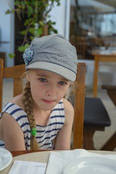 Beautiful blonde little girl sitting on the table