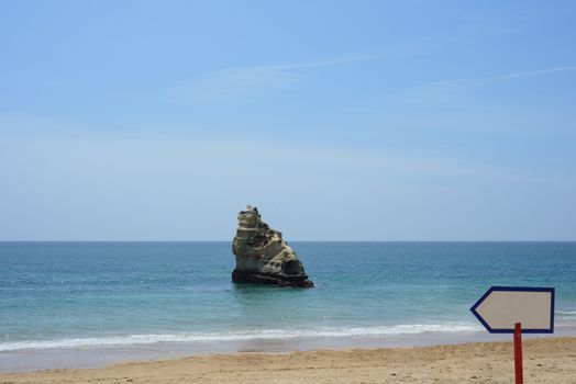 Rock cliff in ocean with empty sign