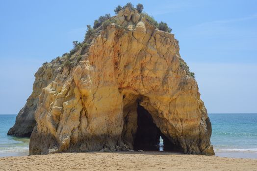 Rock with cave in the ocean on beach