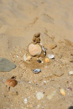 Pyramid of sand, stones and shells on the beach