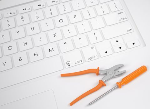 Pliers and screwdriver on the keyboard. View from above