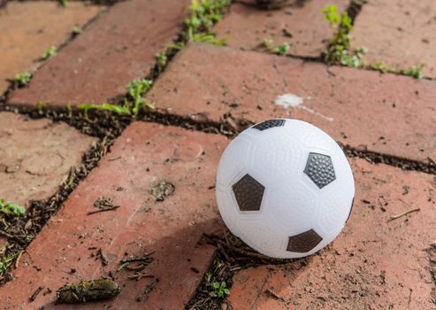 a beautiful black and white soccer ball on the brick surface