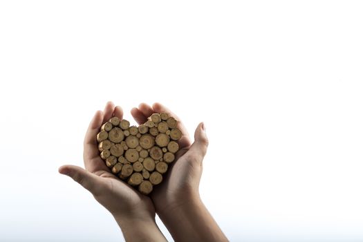 Young hands giving wooden knots heart on white background