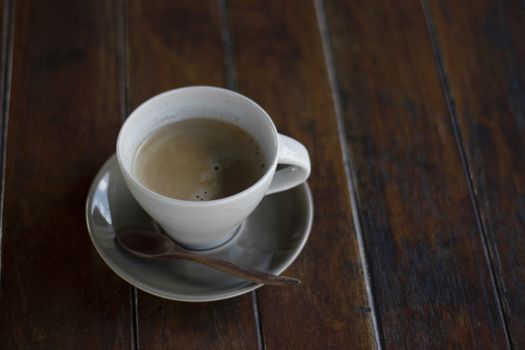 A cup of coffee on wooden background