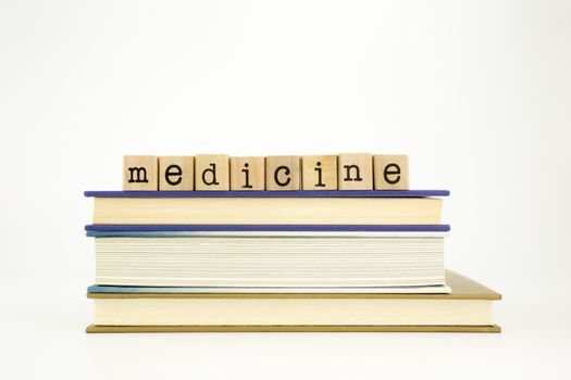 medicine word on wood stamps stack on books, academic and study concept