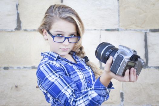 Funky cool contemporary teenager with glasses and a camera taking self portrait, a selfie, soft focus