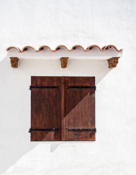 A close up of a Spanish window with the shutters closed 