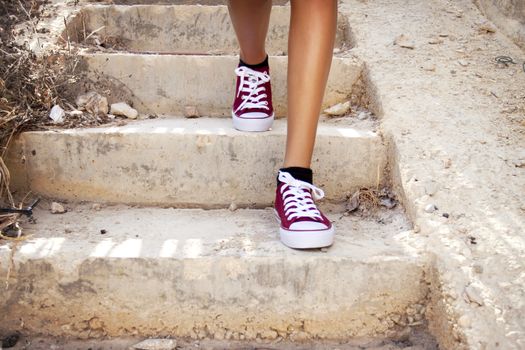 Feet with red trainers on stairs