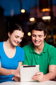 Smiling couple using a digital tablet in restaurant