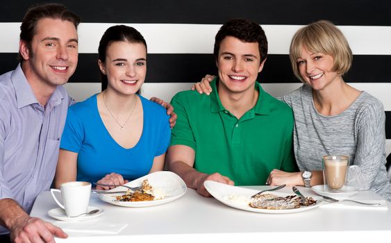 Family of four enjoying breakfast together