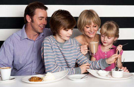 Cheerful family of four enjoying breakfast at a restaurant