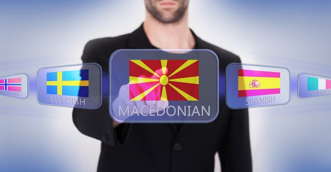 Hand pushing on a touch screen interface, choosing language or country, Macedonia