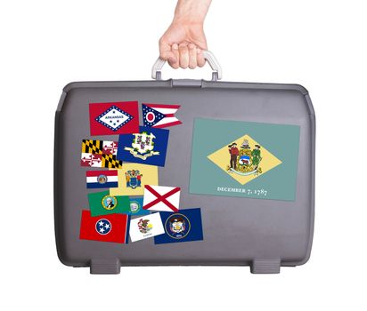 Used plastic suitcase with stains and scratches, stickers of US States, Delaware