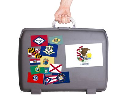Used plastic suitcase with stains and scratches, stickers of US States, Illinois