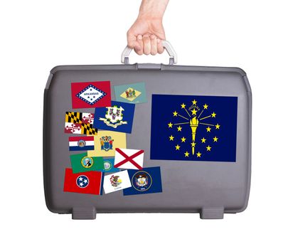 Used plastic suitcase with stains and scratches, stickers of US States, Indiana