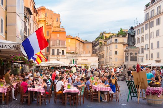 ROME, ITALY - JUNE 13 2014: People having aperitif which in Italy traditionally includes free all you can eat buffet of pizzas and pastas, on JUNE 13 2014 on Piazza Campo De Fiori in Rome in Italy.