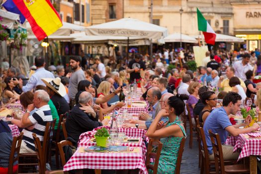 ROME, ITALY - JUNE 13 2014: People having aperitif which in Italy traditionally includes free all you can eat buffet of pizzas and pastas, on JUNE 13 2014 on Piazza Campo De Fiori in Rome in Italy.