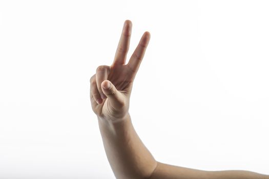 Young hands makes a gesture: victory sign with two fingers