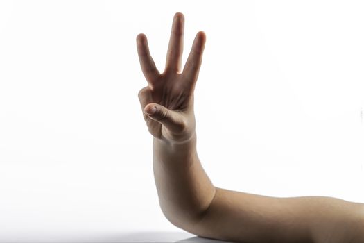 Young hands makes a gesture: number three sign with 3 fingers