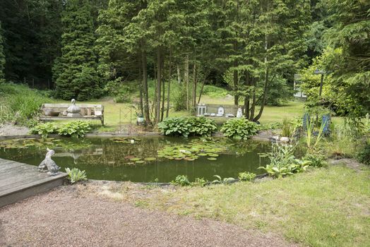 english garden with pond bech water trees and flowers