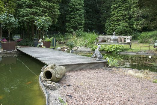 english garden with pond water bridge seat and old vases