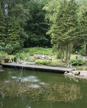 english garden with pond water bridge seat and old vases