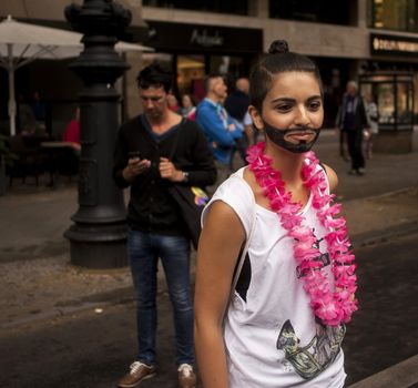 BERLIN, GERMANY - JUNE 21, 2014: Christopher Street Day.Crowd of people Participate in the parade celebrates gays, lesbians, bisexuals and transgenders.Prominent in the image a participant disguised as Conchita Wurst.