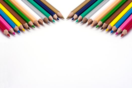 Colored pencils in a line on a white backgound 