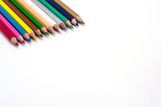 Colored pencils in a line on a white backgound 