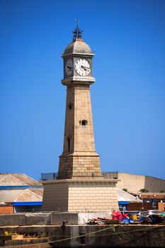 Stone tower with clock (Torre del Rellotge) one of the city most iconic buildings - built in 1772 in Port Vell, Barcelona Spain